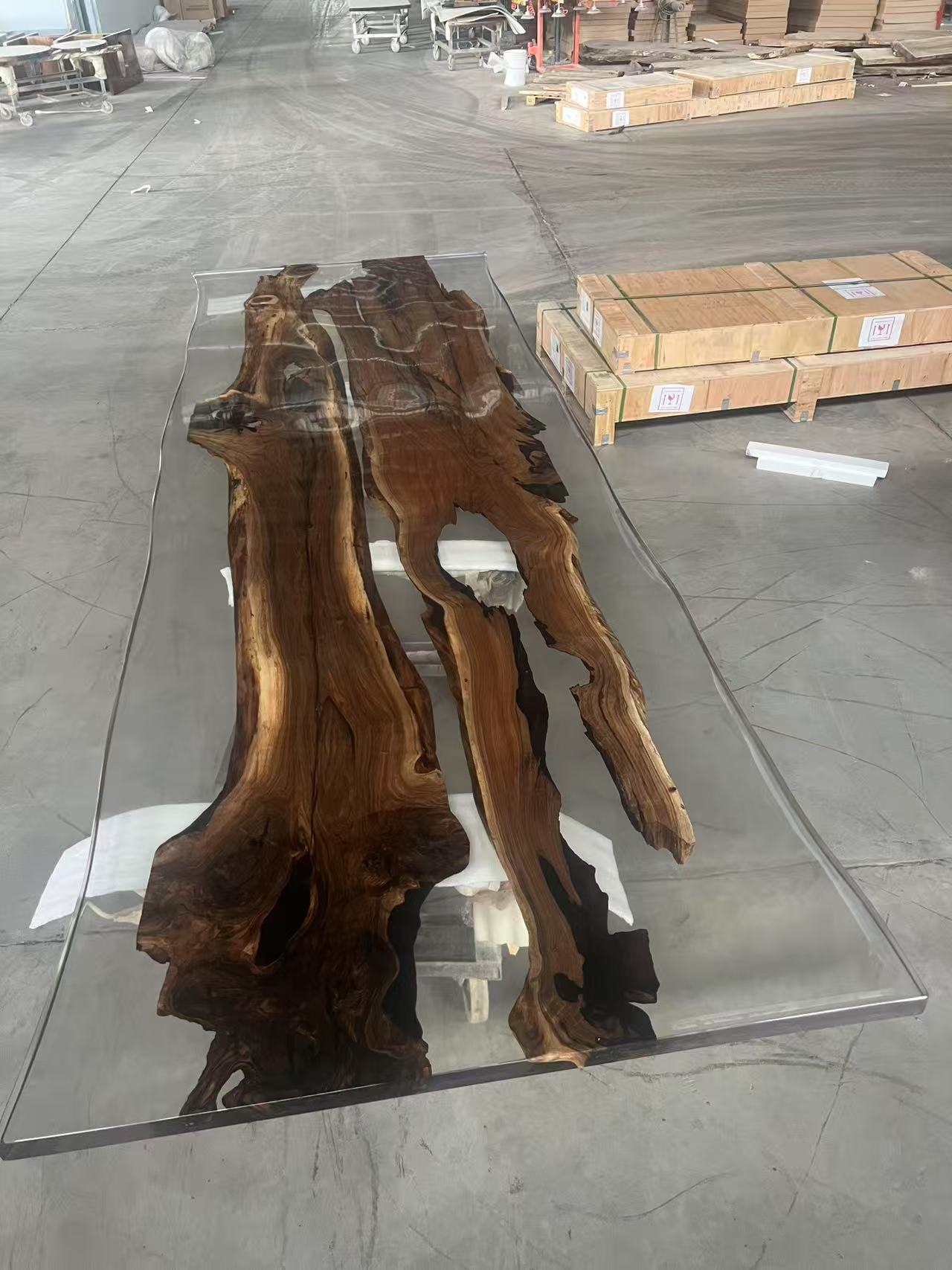Wooden table with a glass top on a concrete floor